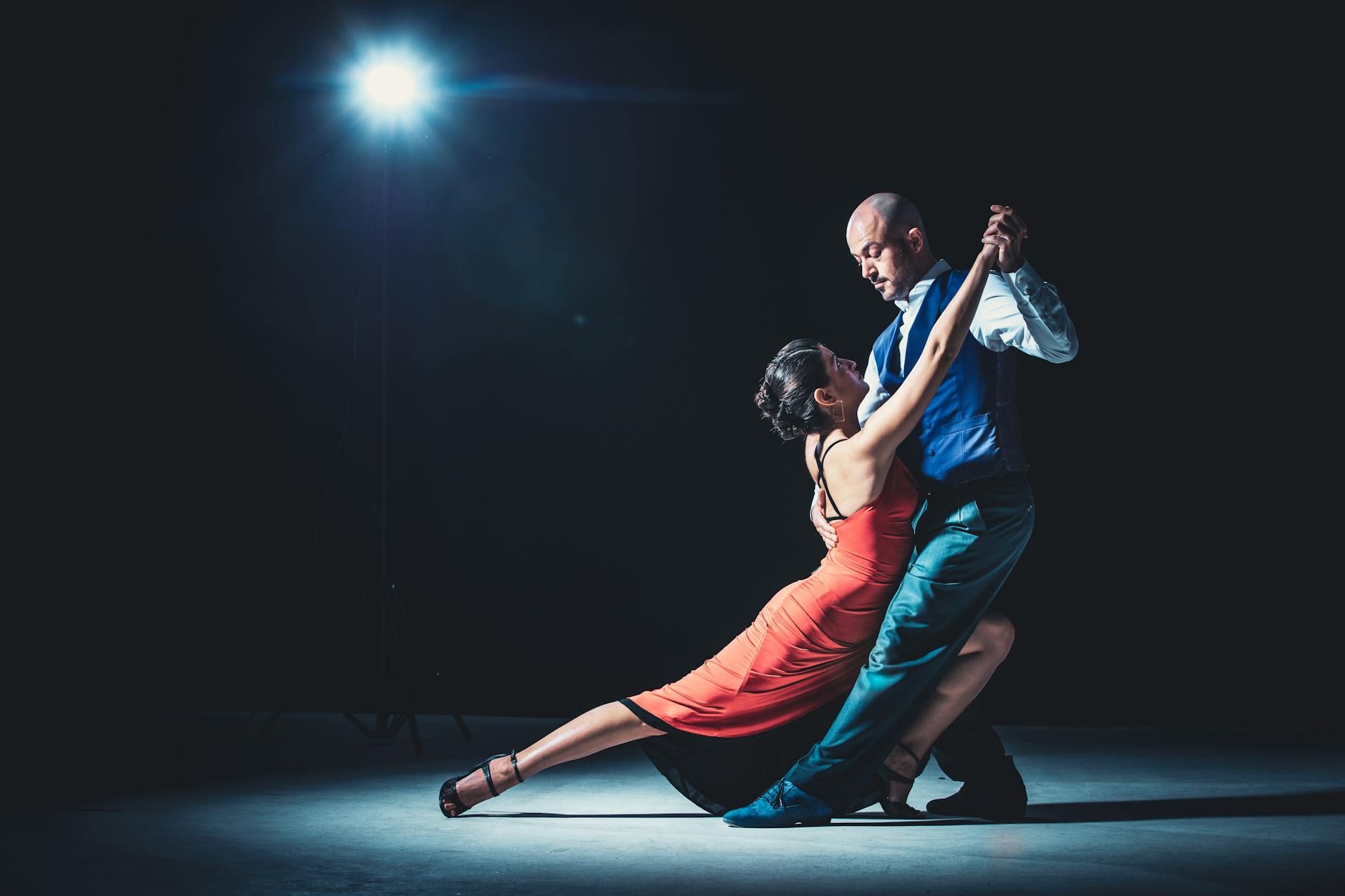 Paar beim Tango unter Dramatischem Scheinwerferlicht
